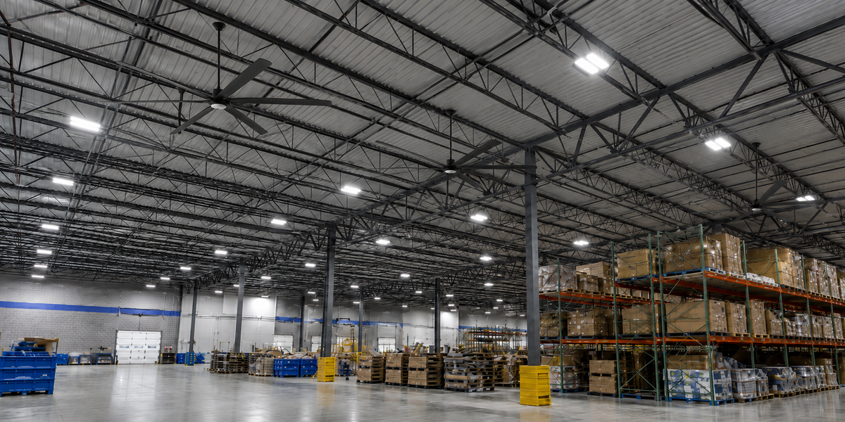 Large industrial ceiling fan installed in a high-ceiling warehouse space.