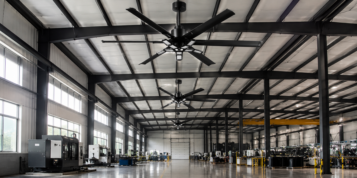 Large black industrial ceiling fans installed in a high-ceiling warehouse.